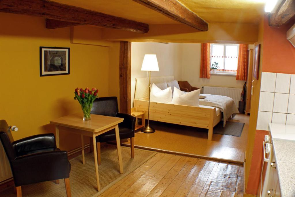 クヴェードリンブルクにあるFerienwohnung Im Dammのベッド、テーブル、椅子が備わるホテルルームです。