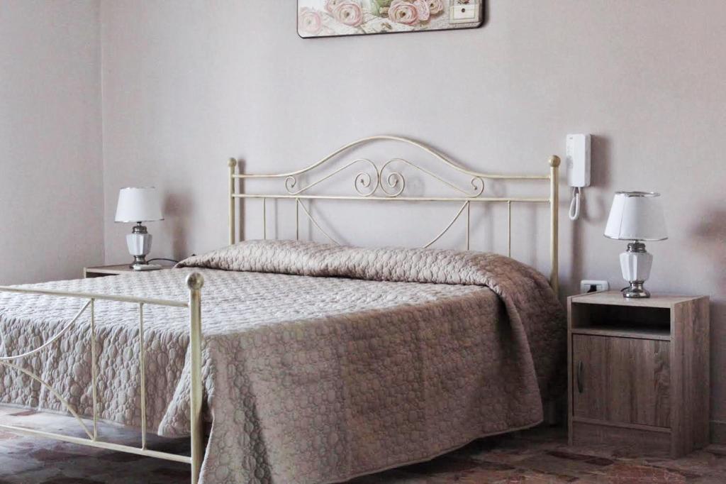 a bed in a bedroom with two night stands and two lamps at Umberto I - Affitti brevi in Favara