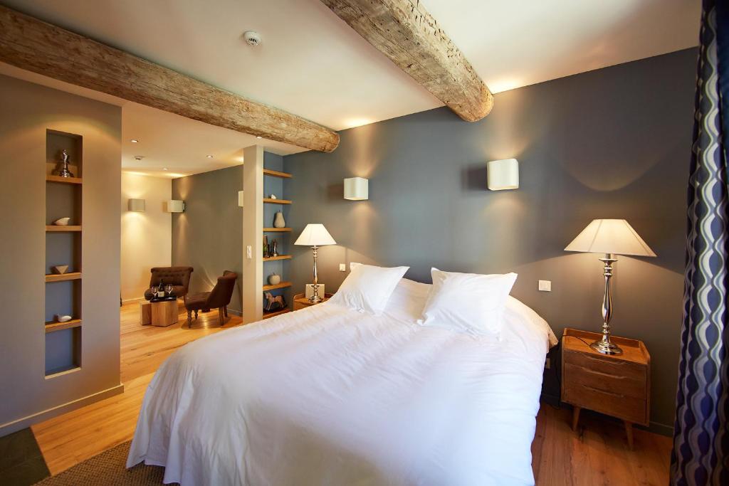 ein Schlafzimmer mit einem großen Bett mit weißer Bettwäsche in der Unterkunft Les Chambres de l'Oustalet in Gigondas
