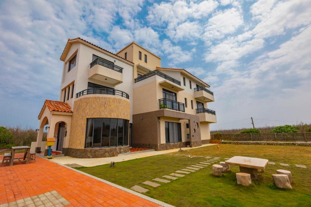 Un gran edificio con una mesa delante. en Love Penghu Homestay, en Huxi