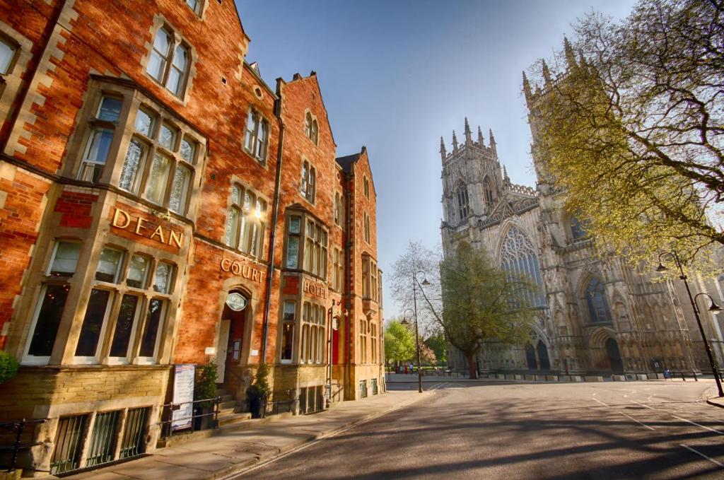 an empty street in front of a building with a cathedral at The Dean Court in York