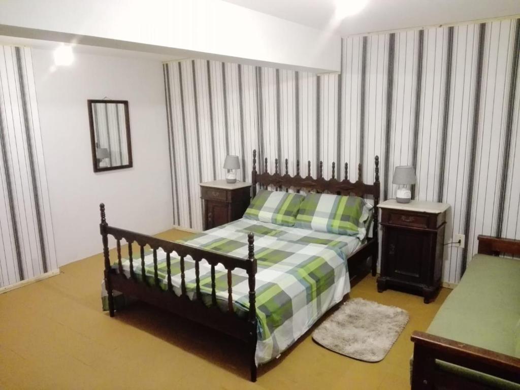a bedroom with a bed with a green and white blanket at Solar de Paz in Rivera