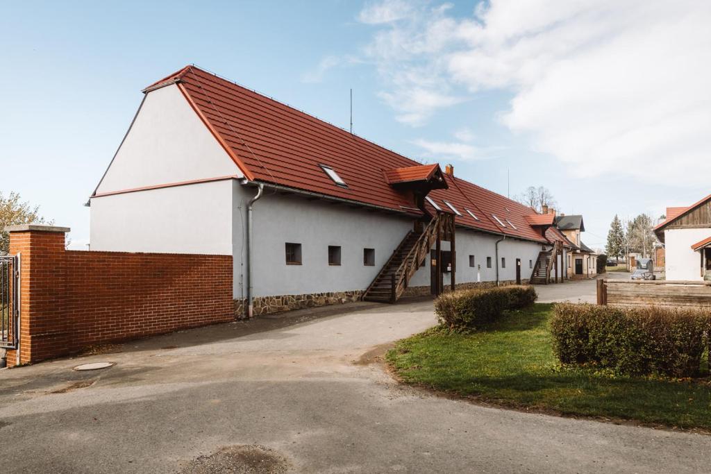 a large white building with a red roof at Farma Klokočov in Vítkov