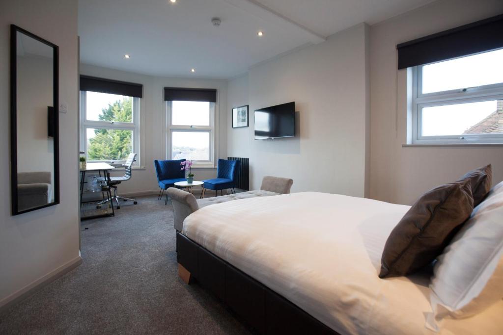 a bedroom with a bed and a desk in a room at Asperion Hotel in Guildford