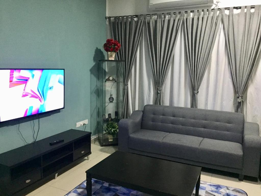 a living room with a couch and a flat screen tv at Homestay DTepian Bayu Bandar Seri Impian Kluang in Kluang