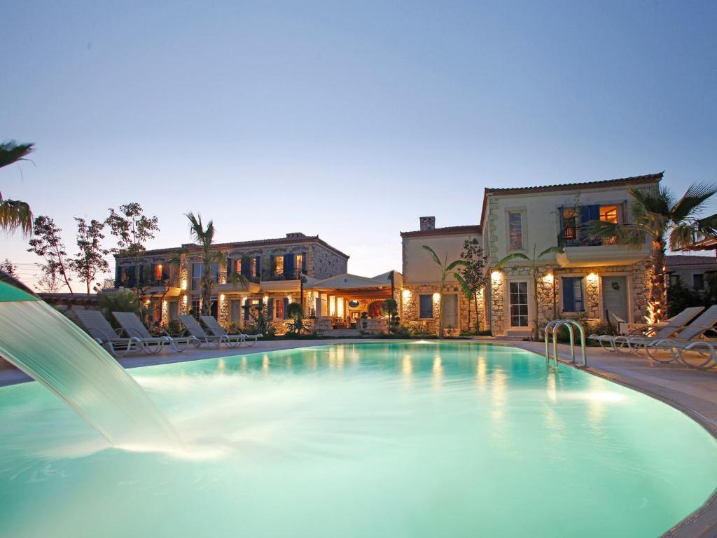 a pool with a water slide in front of a building at Alacati Igdelihan Unique Hotel in Alacati