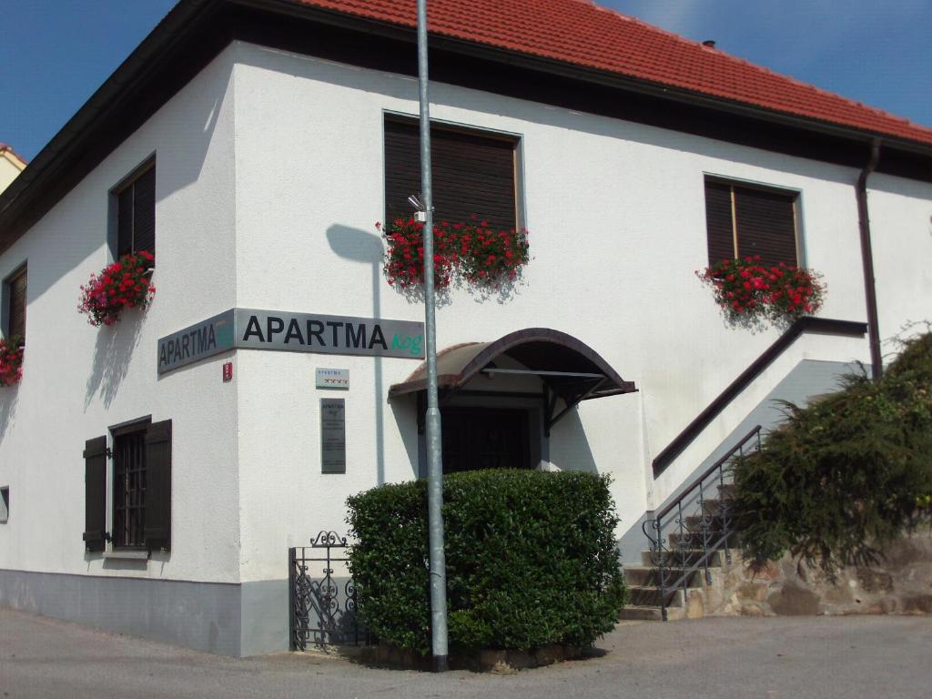 a street sign in front of a white building at POČITNIŠKA HIŠA KOG in Kog