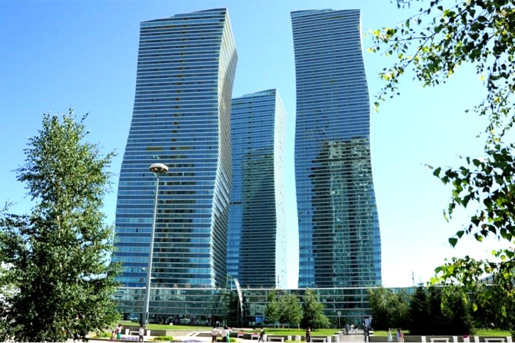 Tre grattacieli alti in una città con un parco di Bon Mary Hotel a Astana
