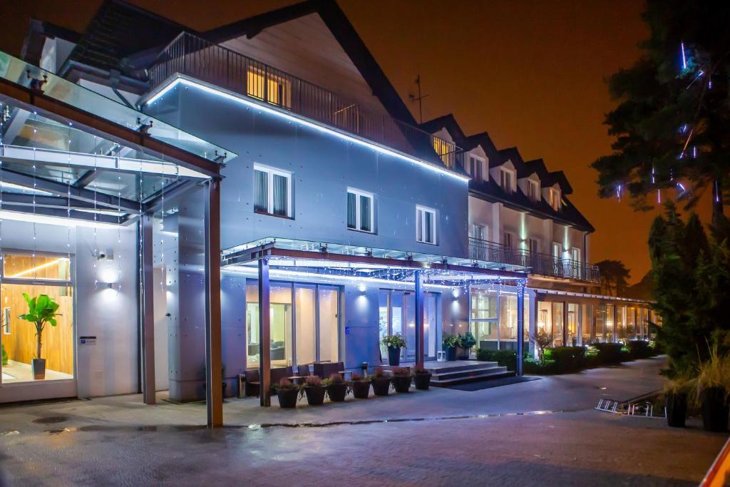 un edificio con luces azules por la noche en Hotel Jantar Wellness & Spa en Ustka