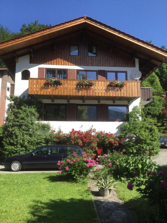 ein Haus mit einem Balkon und einem Auto vor dem Haus in der Unterkunft Gästehaus Kochelsee in Kochel