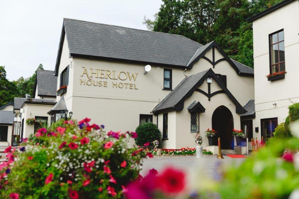 una casa blanca con un cartel que lee hotel de la casa del altar en Aherlow House Hotel & Lodges, en Aherlow
