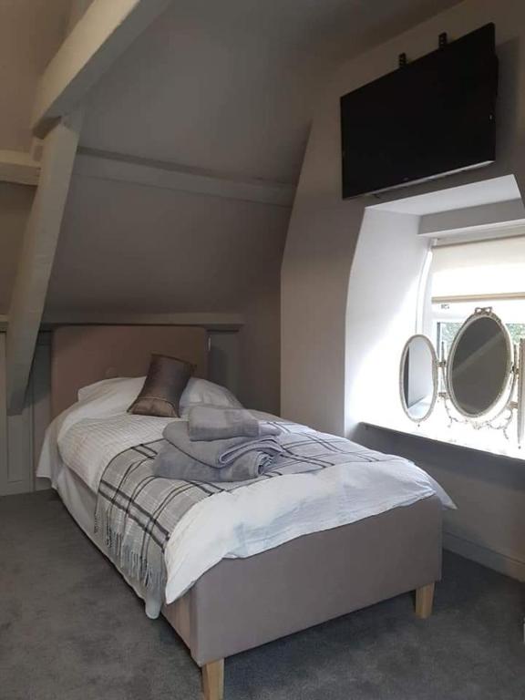 1 dormitorio con 1 cama con 2 espejos en la pared en The Swan en Topcliffe