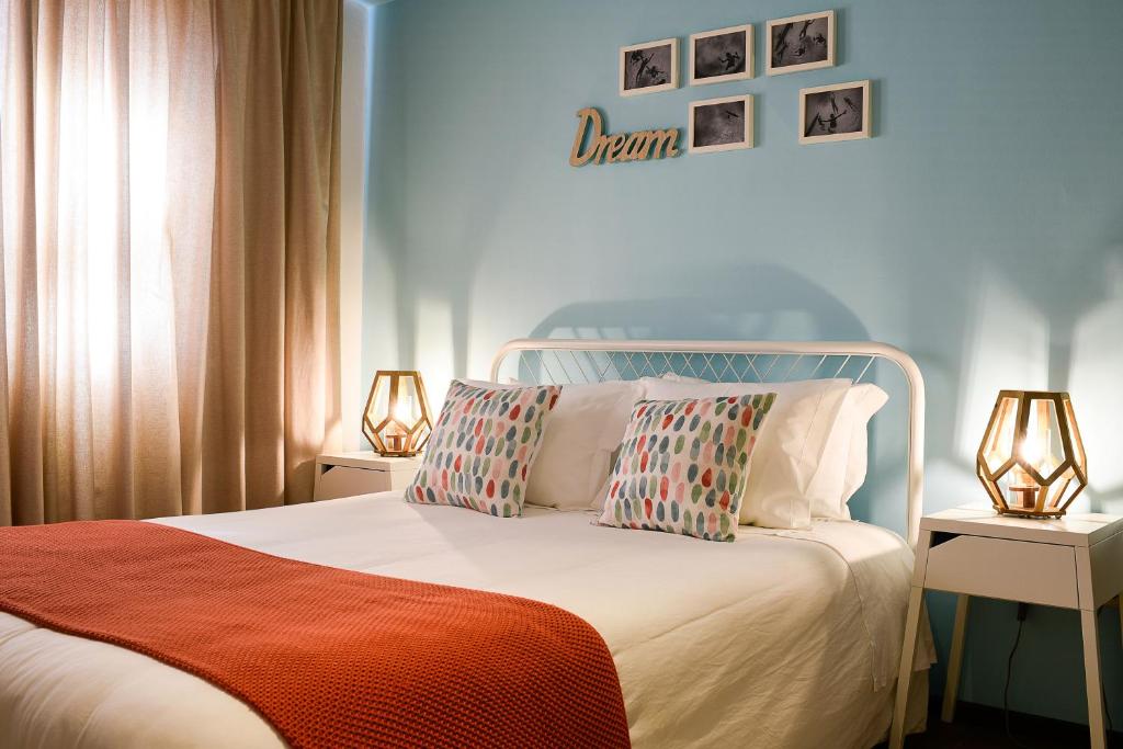 a bedroom with a white bed with two lamps on tables at The Sea Beach House in Cortegaça