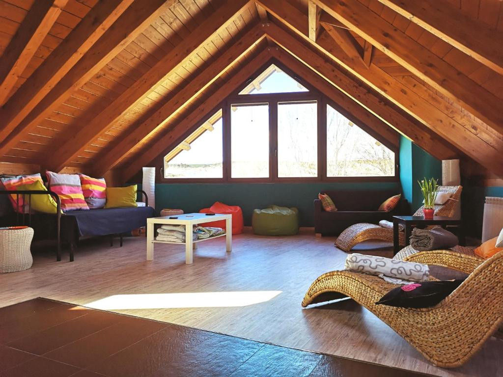 a living room with couches and chairs in a attic at Casa Gomez in Santa Cilia de Jaca
