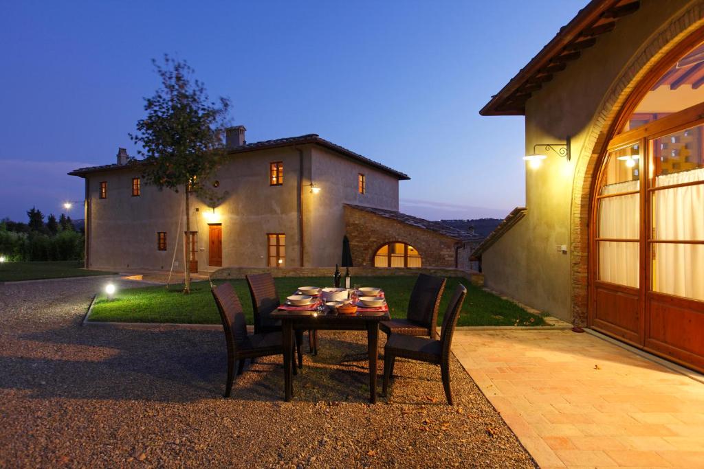 uma mesa com cadeiras em frente a uma casa em Podere Le Rondini em Montespertoli