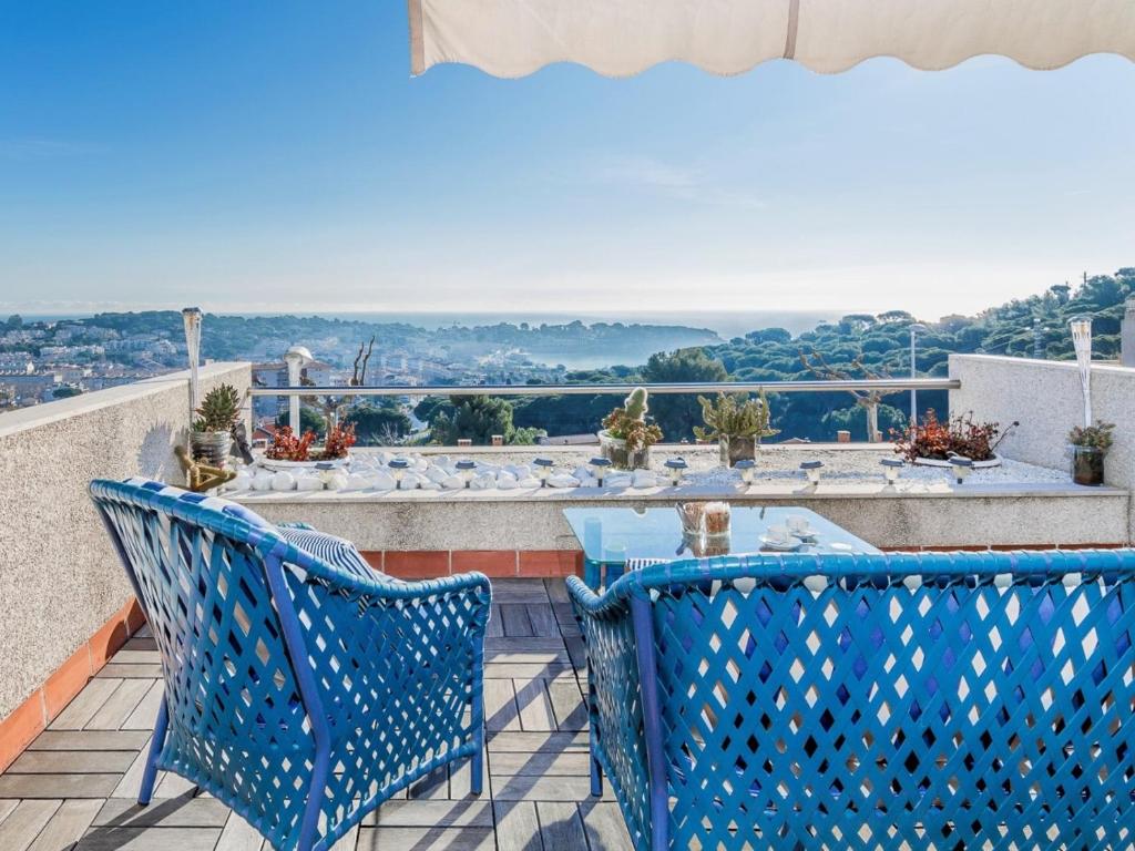 Un balcón con 2 sillas azules y una mesa. en Casa pilar en S'Agaró