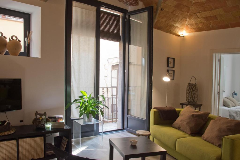 a living room with a yellow couch and a large window at Can Pauet Apartaments in Palamós