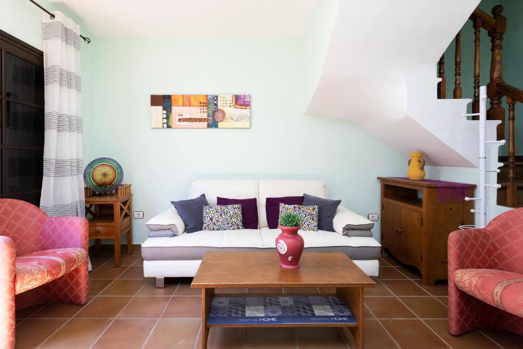 un soggiorno con un divano bianco e 2 sedie di Home2Book El Médano Cozy Beach & Wifi a El Médano
