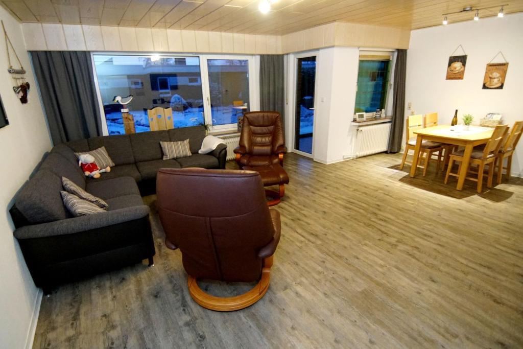 a living room with a couch and chairs and a table at Bungalow Windsbraut in Norddeich