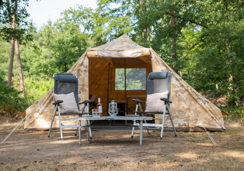 einen Tisch und zwei Stühle vor einem Zelt in der Unterkunft Tent-Ok Meppen in Meppen