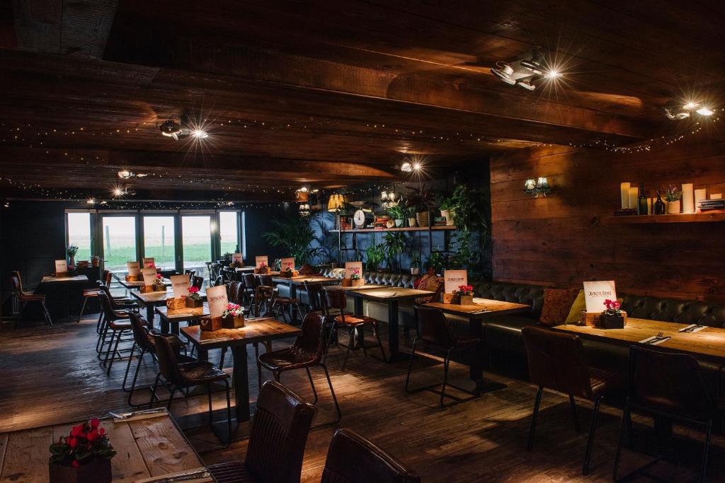 a restaurant with wooden floors and tables and chairs at The Joiners Arms in Chathill
