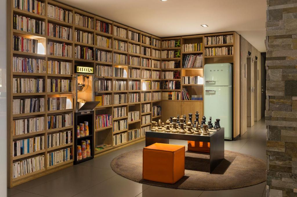 a library with a chess board and bookshelves at Heliopic Hotel & Spa in Chamonix