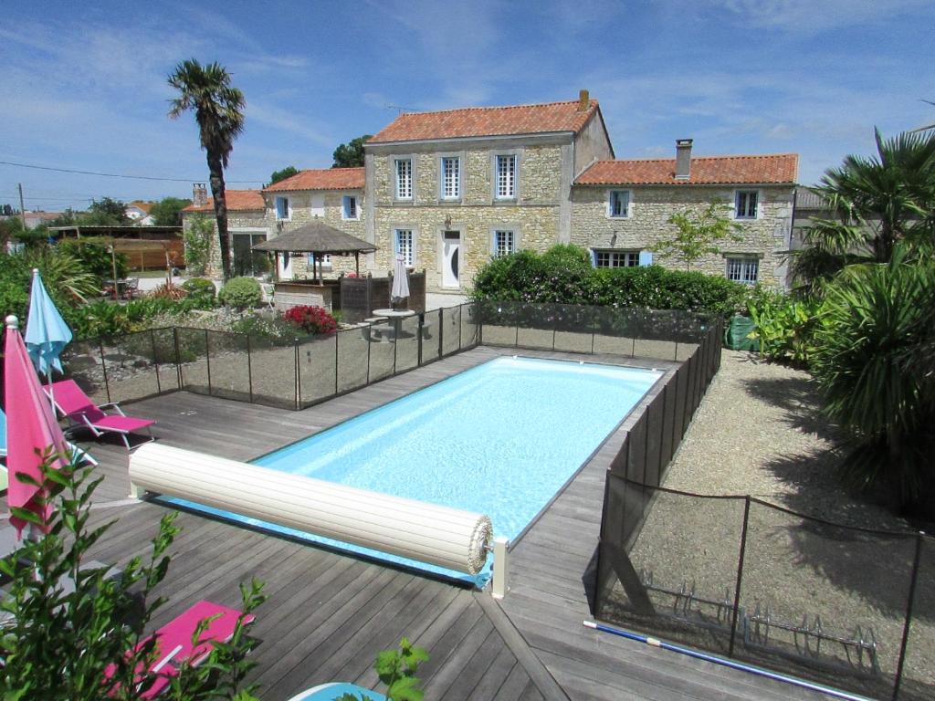 a swimming pool in front of a house at Logis de Chalons à la mer in Le Gua