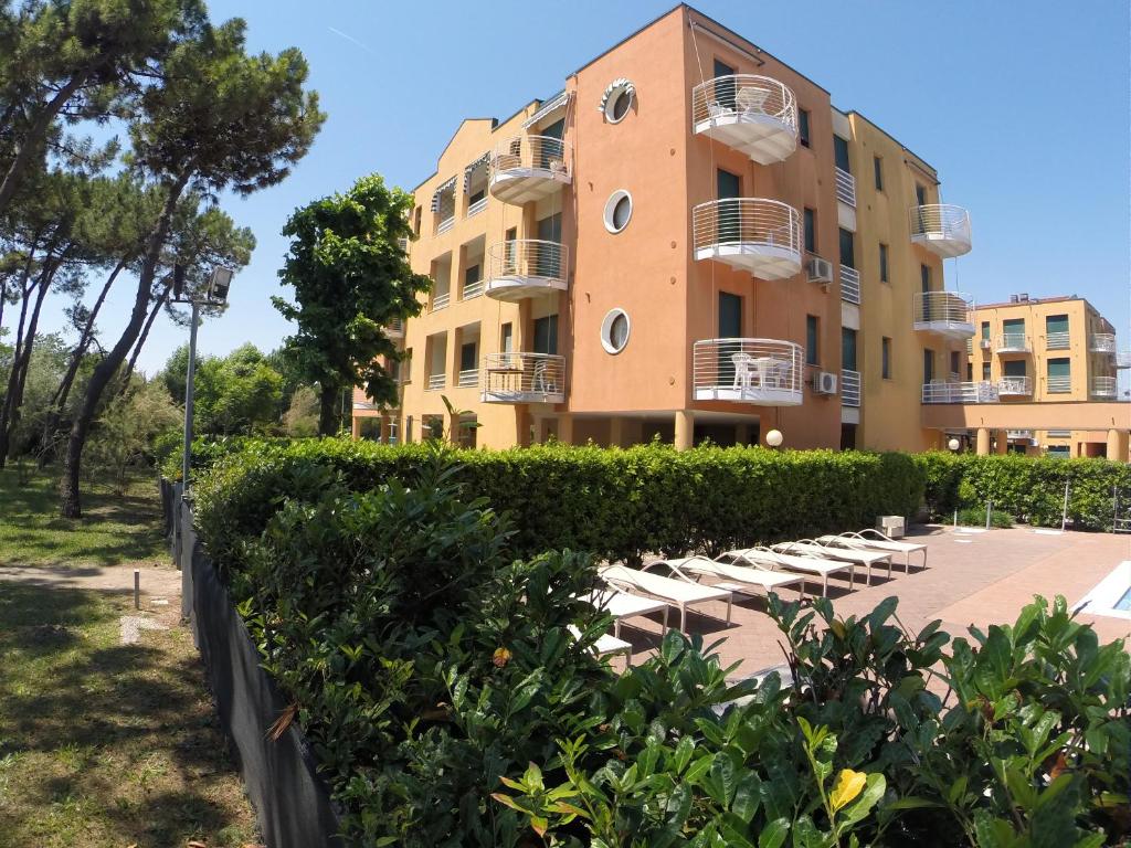 カヴァッリーノ・トレポルティにあるCorallo Apartmentsのラウンジチェア付きの建物