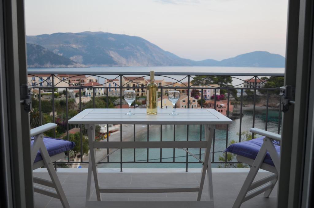 un tavolo con 2 bicchieri da vino sul balcone di Romanza Studios ad Ásos