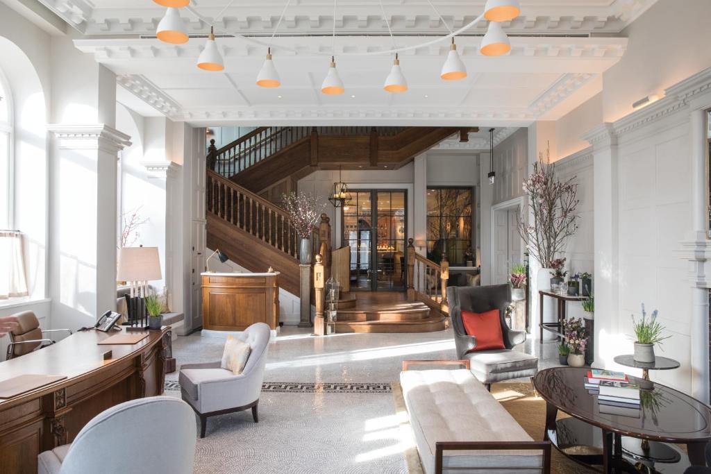 una sala de estar con muebles y una escalera. en The Cadogan, A Belmond Hotel, London, en Londres