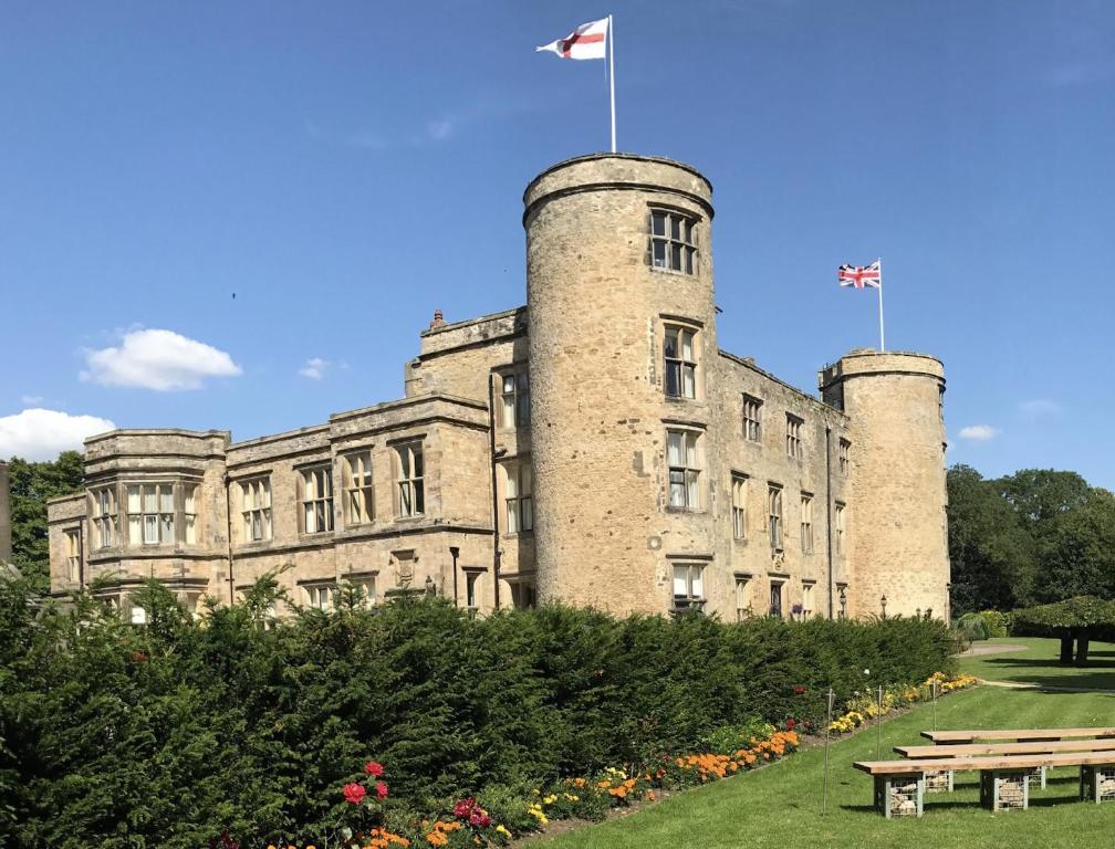 un bâtiment avec deux tours et deux drapeaux au-dessus dans l'établissement Best Western Walworth Castle Hotel, à Darlington