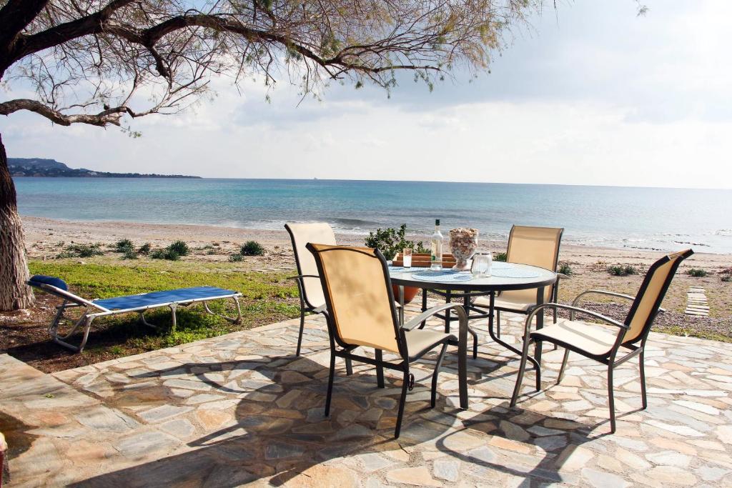 a table and chairs on a patio overlooking the beach at Marina Beach House in Lartos