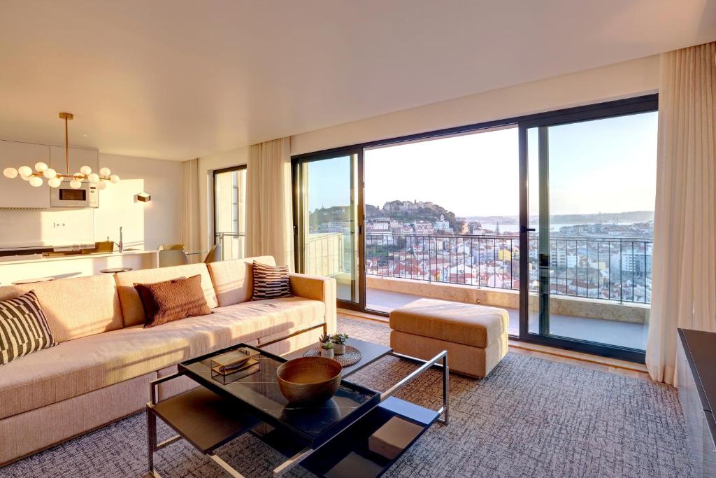 - un salon avec un canapé et de grandes fenêtres dans l'établissement Luxury Graça Apartment The Most Amazing View of Lisbon, à Lisbonne