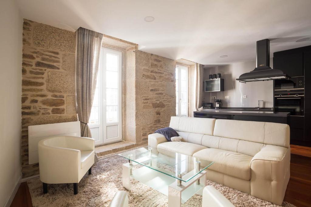 a living room with a white couch and a glass table at Luxury apartment-free parking in Santiago de Compostela