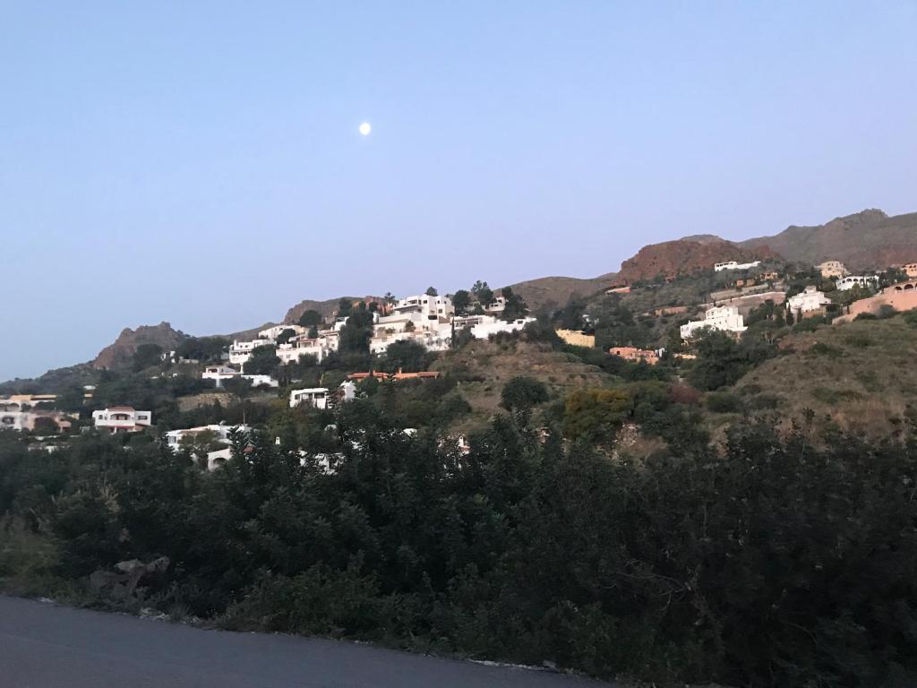 un grupo de casas blancas en una colina junto al agua en Hospedería Ancladero, en Mojácar