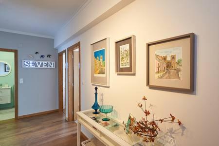 a room with a glass table and paintings on the wall at Seven Guest House in Falagueira