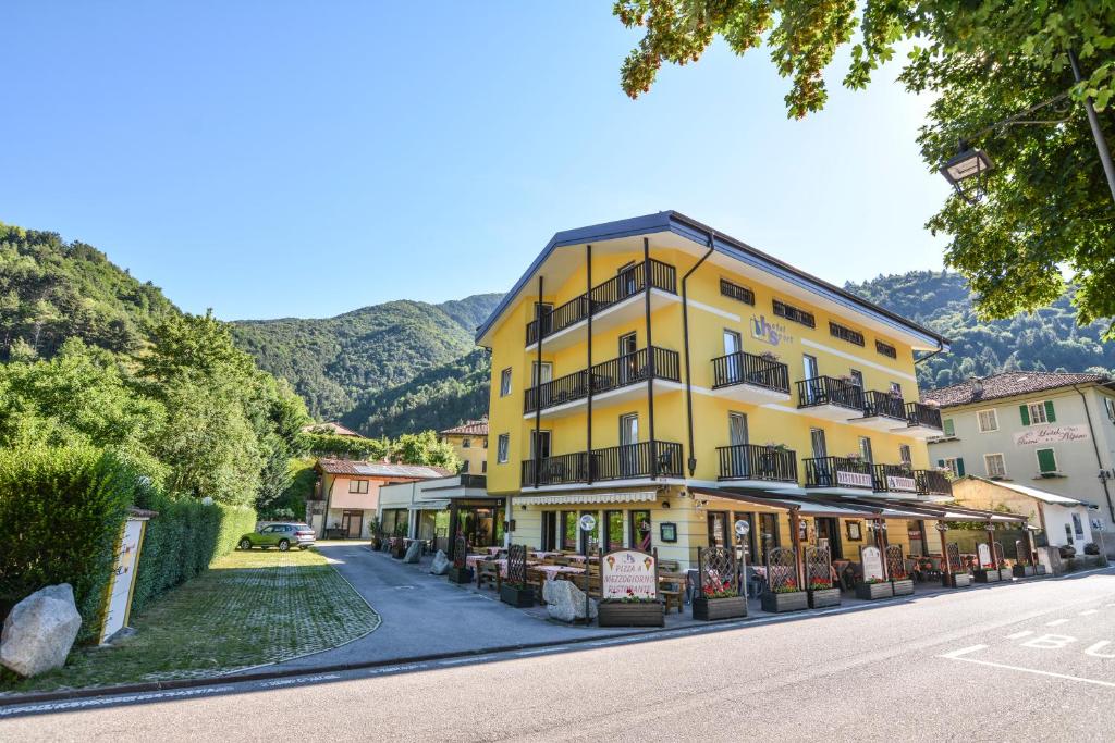 ein gelbes Gebäude an der Straßenseite in der Unterkunft Hotel Sport in Ledro