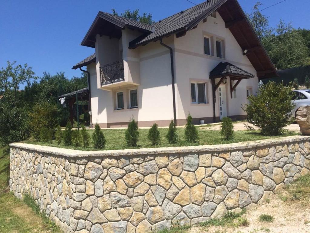 Charming Luxury Villa في سراييفو: منزل أمامه جدار حجري
