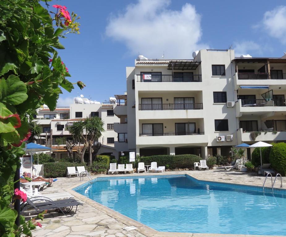 a hotel with a swimming pool in front of a building at Kings Avenue - Natalia's Apt in Paphos