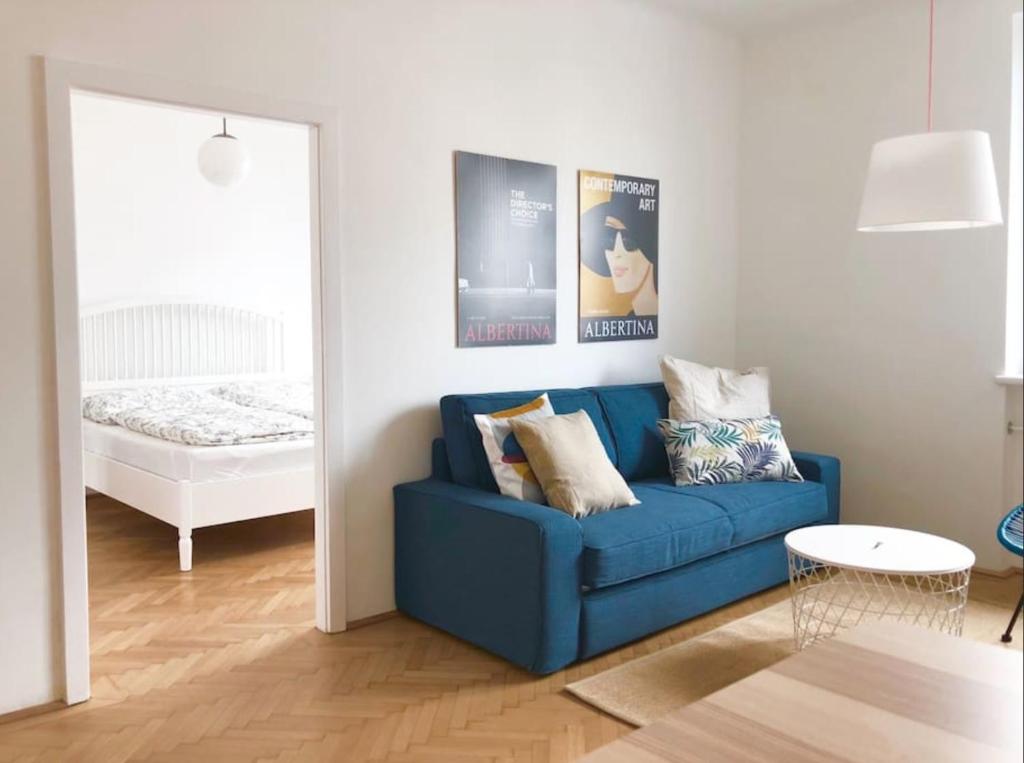a blue couch in a living room with a bed at Bright, lovely and quiet apartment at the heart of Vienna, Nachmarkt, City center in Vienna