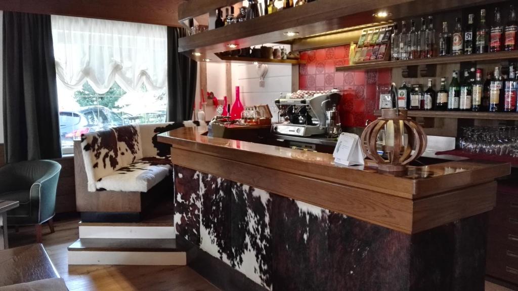 eine Bar mit Theke und Kaffeemaschine in der Unterkunft Hotel Alaska in Campitello di Fassa
