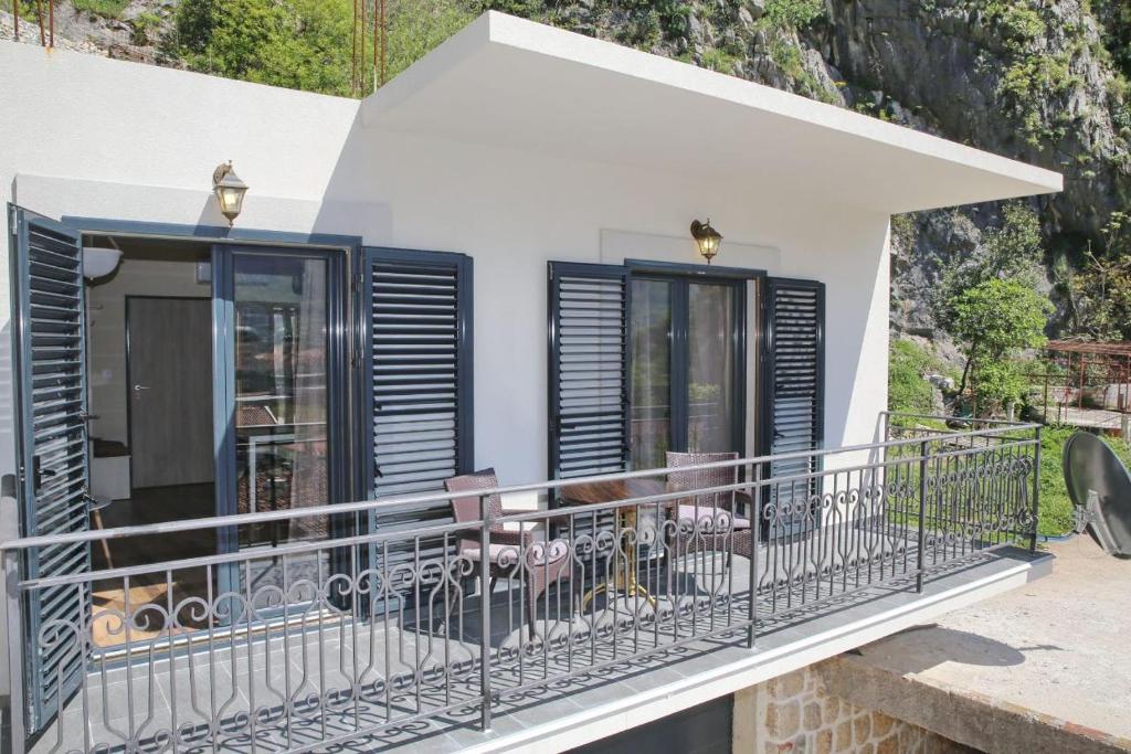 uma casa com uma varanda com persianas pretas em Anja em Kotor