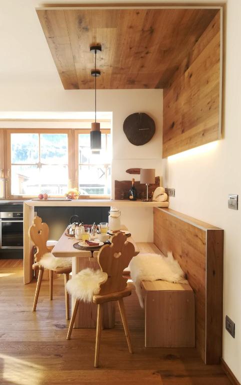 a kitchen with a table and chairs in a room at Ciasa David Marebbe in San Vigilio Di Marebbe