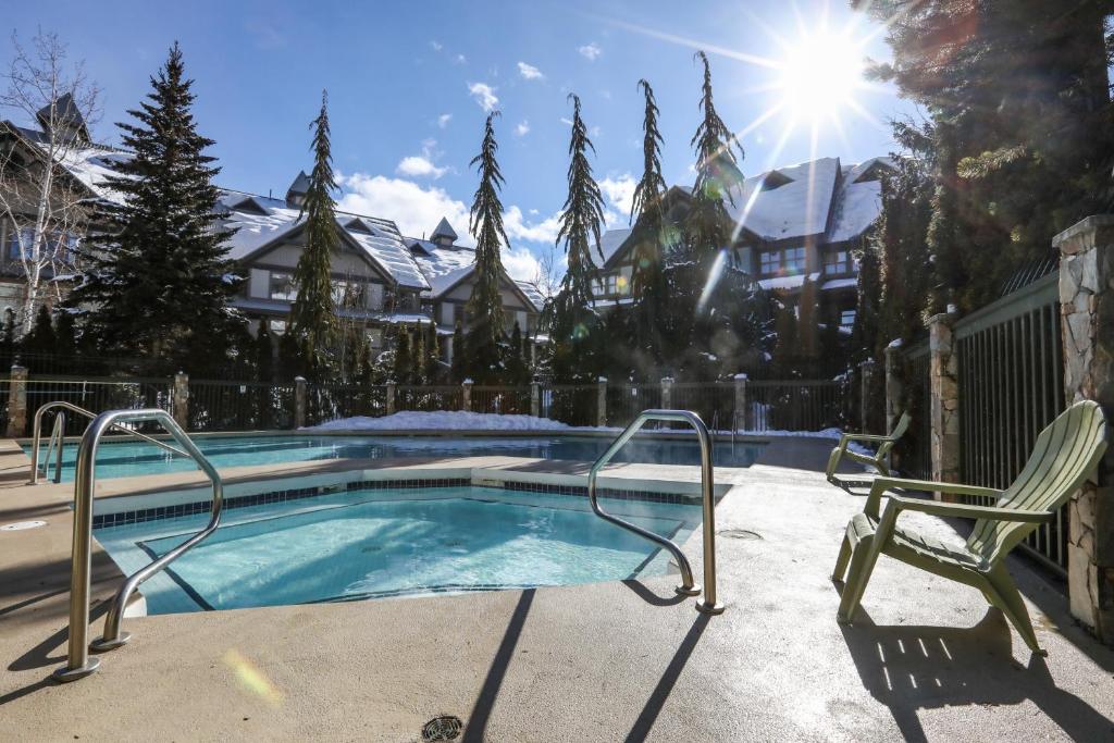 a swimming pool with two lawn chairs next to it at Northstar at Stoney Creek by Whiski Jack in Whistler