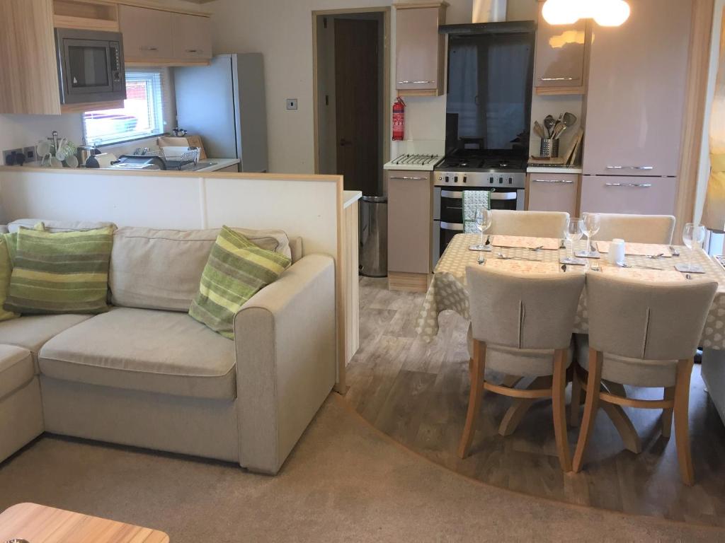sala de estar con sofá y mesa en Honeydukes Holiday Lodge, Boat of Garten, Aviemore, en Boat of Garten