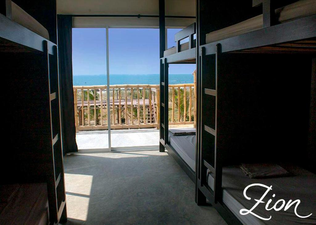 1 dormitorio con vistas al océano desde el balcón en Zion Beach House en Cartagena de Indias