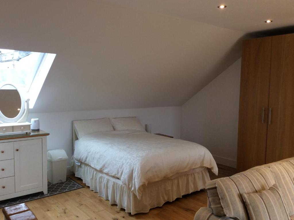 1 dormitorio con cama blanca y ventana en West Highland Way Rooms ED30002F, en Milngavie