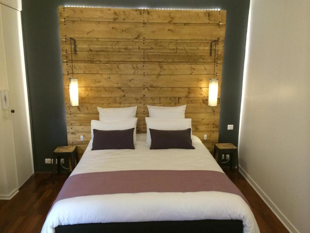 a bedroom with a large bed with a wooden headboard at Studio cosy centre historique Saint-Michel in Bordeaux