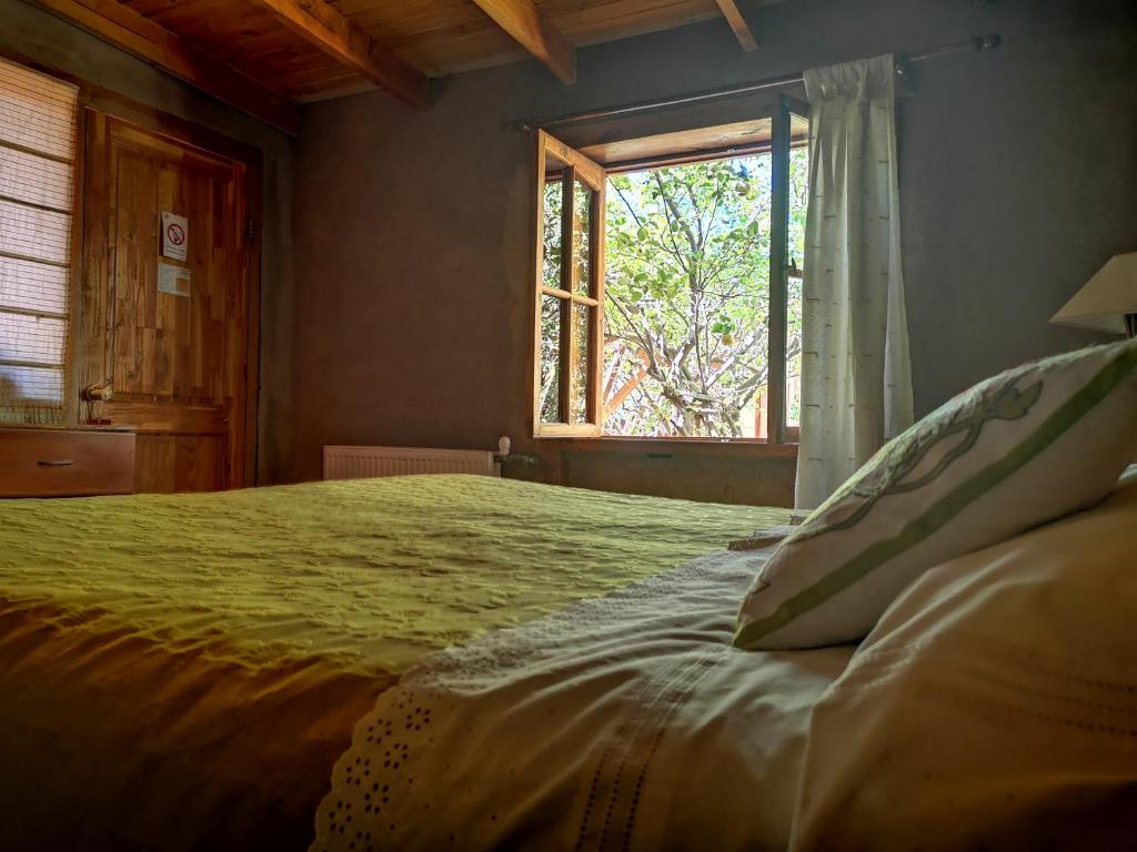 a bedroom with a large bed with a window at Hostal Elim in San Pedro de Atacama
