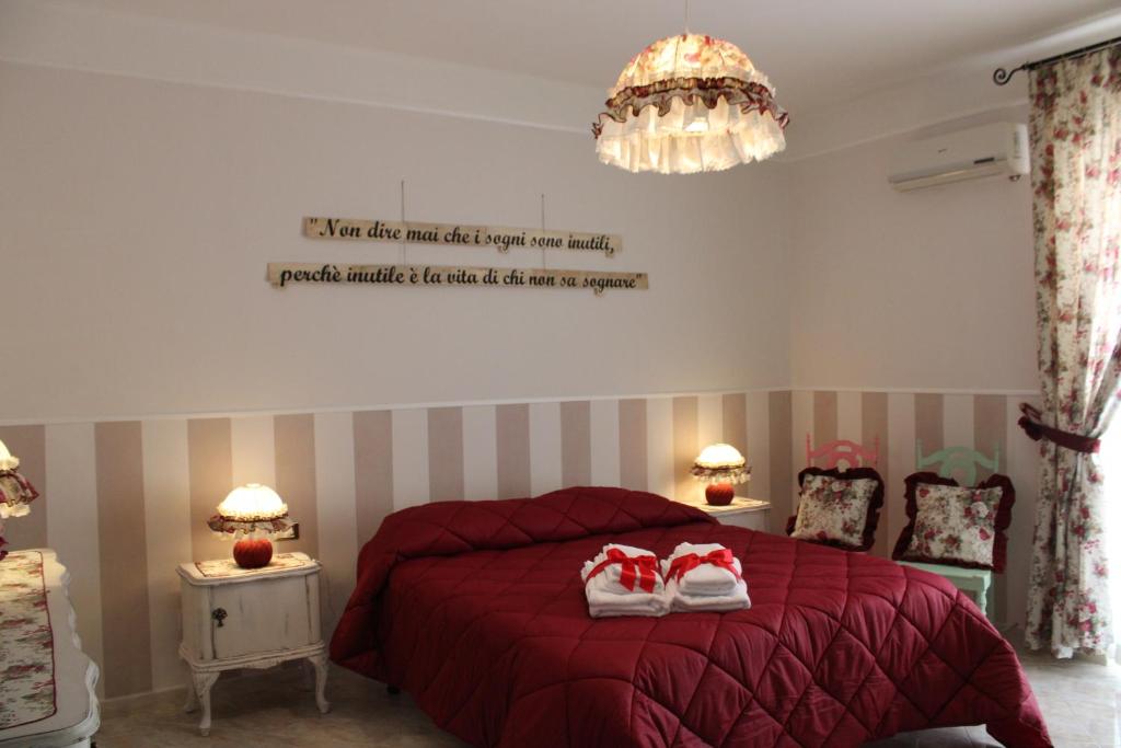 1 dormitorio con 1 cama roja y 2 toallas en Suite Liberty en Taranto